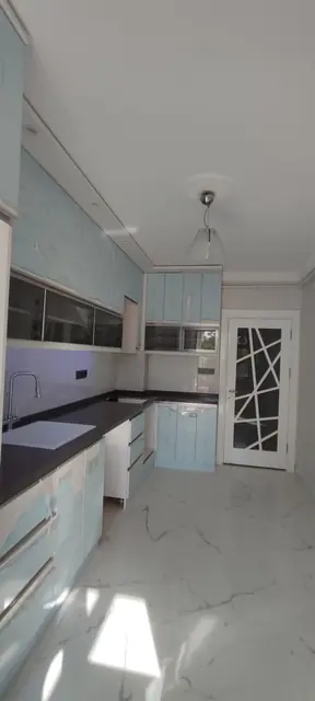 Beyaz ve gri mutfak, cam kapaklı üst dolaplar