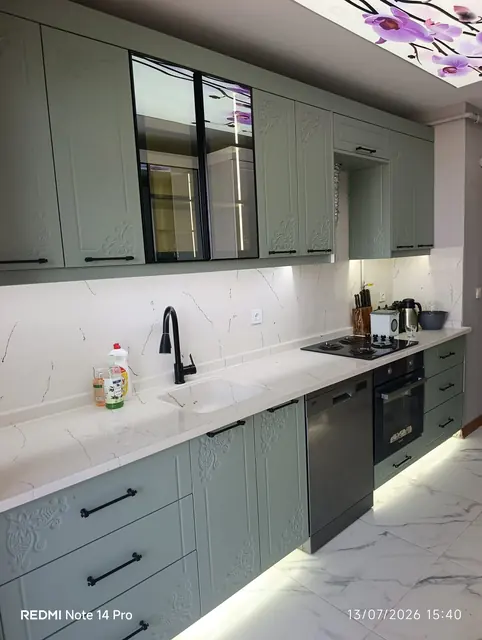 Yeşil lake mutfak dolabı, cam kapaklı üst modül ve LED süpürgelik